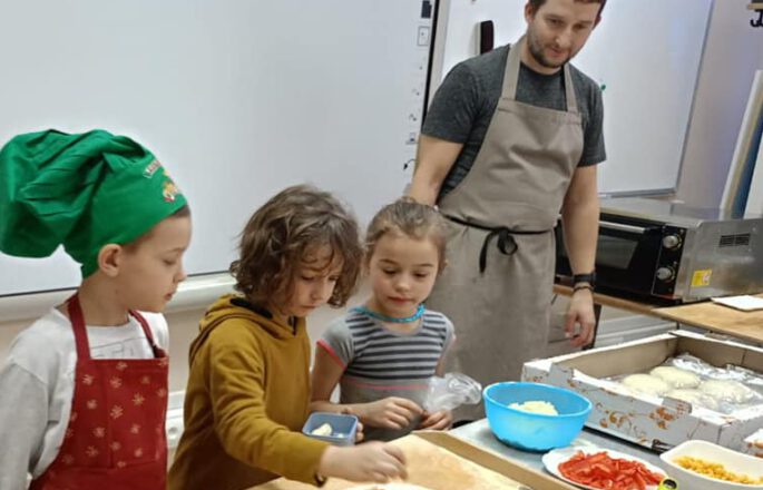 dzieci przygotowywujące pizze
